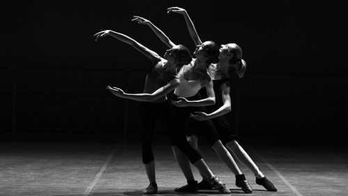 Three ballet dancers with arms and legs outstretched